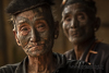 <p><strong>2023 ––India -Nagaland - Mon</strong></p>
<p>Nei remoti villaggi del distretto di Mon in Nagaland, al confine con il Myanmar, è ancora possibile vedere un’eterogenea banda di vecchi ex guerrieri. Sono un club molto ristretto di anziani dai tatuaggi sbiaditi e con corna di animali infilati nei lobi delle orecchie, dalle espressioni a tratti orgogliose e a tratti malinconiche. Sembrano anche abbastanza gentili, ma i tatuaggi sul viso rivelano una verità più oscura: una volta erano i temibili cacciatori di teste della tribù Konyak.</p>
<p>Tatuaggi rituali, il mito totemico, il culto della conservazione dei crani dei nemici, i riti di iniziazione, gli spiriti evocati con l’aiuto dell’oppio. Popoli guerrieri, popoli fieri, popoli considerati tra gli ultimi cacciatori di teste.</p>
<p>Il Nagaland trasuda fascino: un vecchio mondo, un patrimonio culturale destinato a perdersi nell’arco di una decina d’anni. Questi uomini sono gli ultimi testimoni di questa tradizione che, quando moriranno, se ne andrà per sempre.</p>